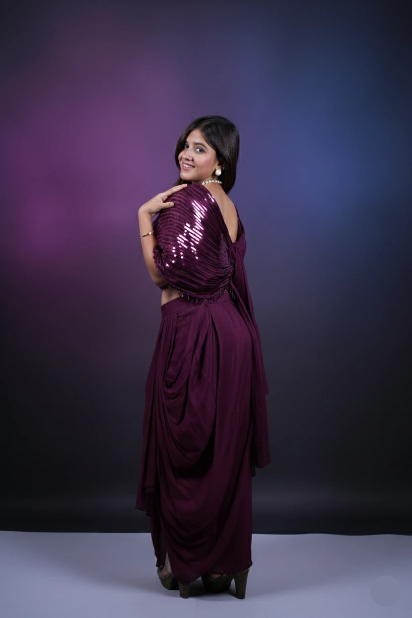 Woman in a purple sequined outfit posing against a gradient purple background