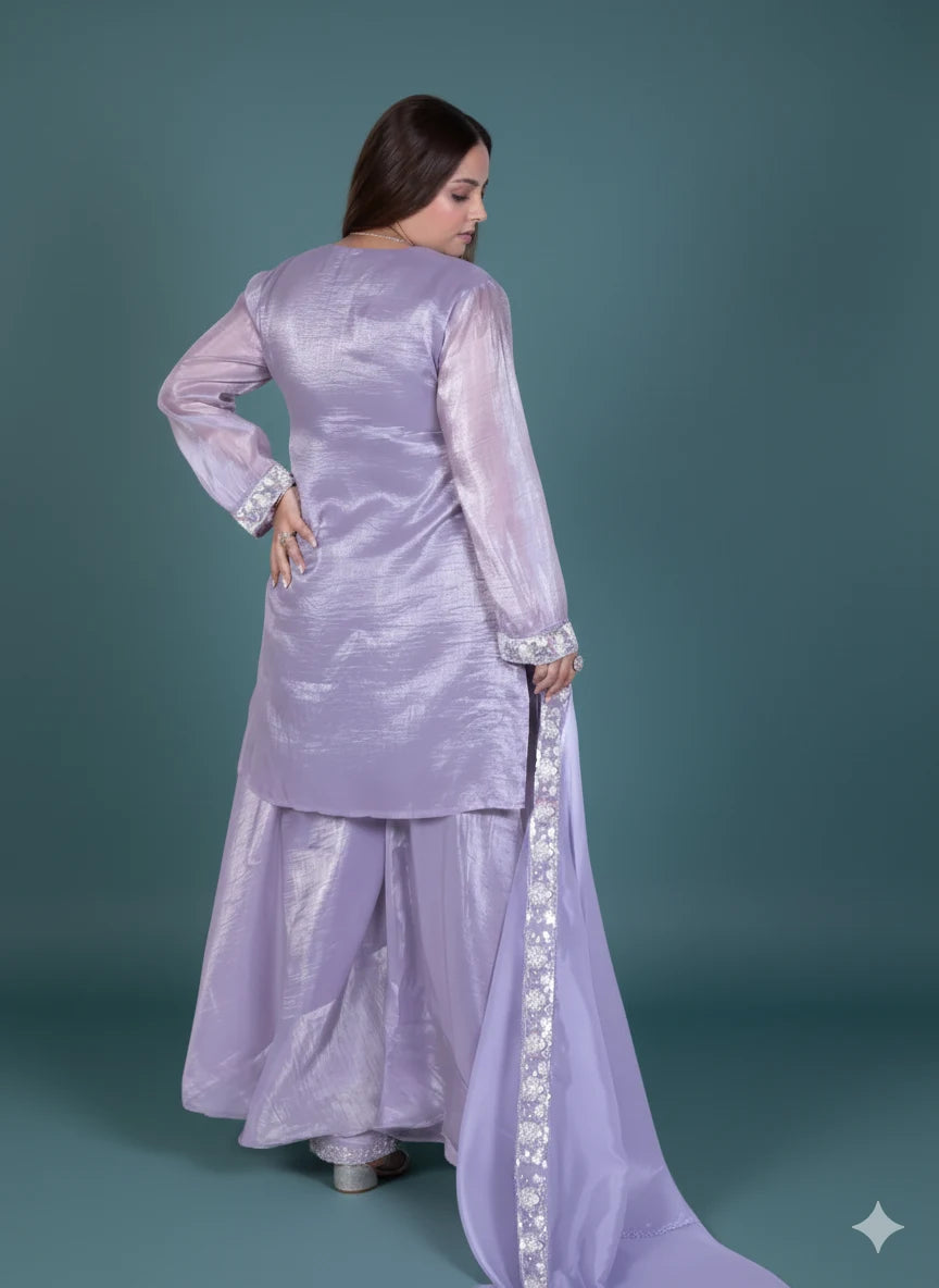 Woman wearing a lavender traditional outfit with a long train on a teal background