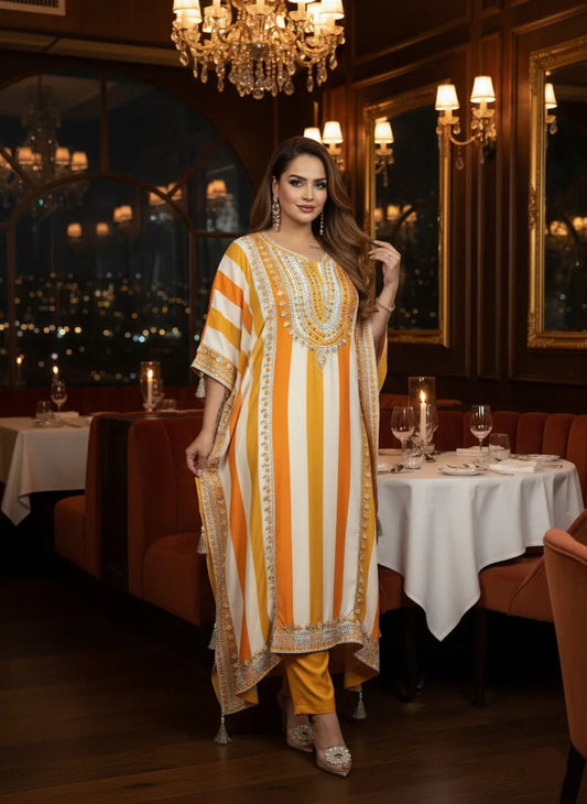 Woman in a patterned outfit standing in a restaurant with elegant decor.