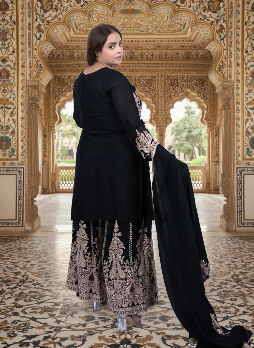 Woman in black traditional outfit with intricate patterns in a ornate indoor setting